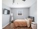 Bedroom featuring a bed, ceiling fan, TV, mirror and light gray walls over wood-look flooring at 9267 N State Road 135, Morgantown, IN 46160
