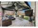 Inviting outdoor deck featuring comfortable seating, rocking chairs, string lights, and a mounted TV, perfect for entertaining at 9267 N State Road 135, Morgantown, IN 46160