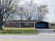 Charming single-story brick home featuring mature trees, and a detached carport on a grassy lot at 9842 N State Road 9, Pendleton, IN 46064