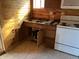 Compact kitchen area with wood cabinets, a double sink, and a white stove at 9842 N State Road 9, Pendleton, IN 46064