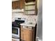 A kitchen featuring a stove and some removed cabinets, with decorative wallpaper at 9842 N State Road 9, Pendleton, IN 46064