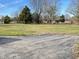 An expansive vacant lot featuring a partially paved drive and mature trees is primed for building at 9842 N State Road 9, Pendleton, IN 46064