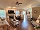 An open-concept living room with hardwood floors, a fireplace, and a view of the dining area at 9947 Comb Run Ct, Avon, IN 46123