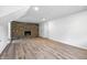 Finished basement featuring wood-look flooring, exposed brick fireplace, and dual closet doors at 1011 Robin Dr, Anderson, IN 46013