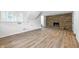 Finished basement featuring wood-look flooring, exposed brick fireplace, and a staircase leading to the upper level at 1011 Robin Dr, Anderson, IN 46013