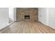 Finished basement featuring wood-look flooring, an exposed brick fireplace, and stair access at 1011 Robin Dr, Anderson, IN 46013