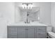Bathroom with grey vanity, white marble countertop, and a large mirror with modern lighting at 1011 Robin Dr, Anderson, IN 46013
