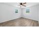 Sunlit bedroom with wood-look floors, ceiling fan, and two large windows at 1011 Robin Dr, Anderson, IN 46013