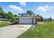 Exterior home view featuring attached garage, driveway, well-maintained lawn, and brick accents at 1011 Robin Dr, Anderson, IN 46013