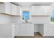 Bright kitchen features white cabinets, subway tile backsplash, and stainless steel sink at 1011 Robin Dr, Anderson, IN 46013