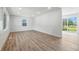 Bright, freshly painted living room featuring new laminate flooring and sliding glass doors to the backyard at 1011 Robin Dr, Anderson, IN 46013