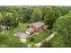 Aerial view of a brick home with an attached garage and a stone patio in a lush green surrounding at 10198 N State Road 75, North Salem, IN 46165