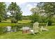 Picturesque backyard featuring a tranquil pond surrounded by lush greenery with chairs at 10198 N State Road 75, North Salem, IN 46165