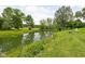 Scenic view of the pond surrounded by lush greenery and grass with seating area at 10198 N State Road 75, North Salem, IN 46165