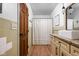 Well-lit bathroom featuring neutral-toned tiles, a wooden door, and a classic vanity with a vessel sink at 10198 N State Road 75, North Salem, IN 46165