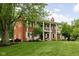 Stately brick home with white columns and shutters, surrounded by lush greenery and mature trees at 10198 N State Road 75, North Salem, IN 46165