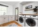 Well-lit laundry room with stainless steel washer and dryer, sink, cabinets, and a window at 10198 N State Road 75, North Salem, IN 46165