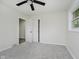 Bright bedroom with a ceiling fan, closet, and neutral-colored walls and carpeting at 10434 N Delaware St, Carmel, IN 46280