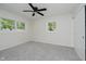 Bright bedroom featuring a ceiling fan, closet, and a window overlooking the outdoor greenery at 10434 N Delaware St, Carmel, IN 46280