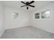 Bright bedroom with two windows, a ceiling fan, and neutral-colored walls and carpeting at 10434 N Delaware St, Carmel, IN 46280
