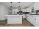 Modern kitchen with stainless steel appliances, white cabinetry, and luxury vinyl flooring at 10434 N Delaware St, Carmel, IN 46280