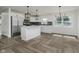 Modern kitchen with stainless steel appliances, center island, and luxury vinyl flooring at 10434 N Delaware St, Carmel, IN 46280