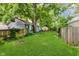 Spacious backyard with healthy lawn, mature trees and wooden fence, perfect for outdoor gatherings at 1051 Elm St, Indianapolis, IN 46203
