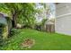 Lush backyard with green lawn, mature trees, and a weathered brick fire pit, ideal for relaxation at 1051 Elm St, Indianapolis, IN 46203