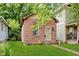 Charming home featuring a red brick facade, green lawn, and a classic design at 1051 Elm St, Indianapolis, IN 46203