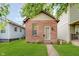 Charming home featuring a red brick facade, green lawn, and a classic design at 1051 Elm St, Indianapolis, IN 46203
