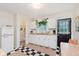 Charming kitchen with a retro fridge, white cabinets, checkered floors, and adjacent bathroom at 1051 Elm St, Indianapolis, IN 46203