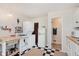 Bright kitchen featuring a laundry station, gas range, retro refrigerator, white cabinets, and checkered floors at 1051 Elm St, Indianapolis, IN 46203