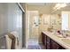 Neutral bathroom with double sinks and vanity features a tile floor and glass shower doors at 10611 Armstead Ave, Indianapolis, IN 46234