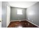 Bedroom featuring hardwood floors, light gray wall color, and ample closet space at 1217 S Ewing St, Indianapolis, IN 46203