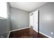 Bedroom with window, hardwood floors, and gray walls leading into another room at 1217 S Ewing St, Indianapolis, IN 46203