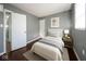 Cozy bedroom featuring a bed, bedside table with lamp, hardwood floors, and neutral wall art at 1217 S Ewing St, Indianapolis, IN 46203