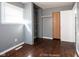 Bedroom with gray walls, window, hardwood flooring, closet storage, and white door at 1217 S Ewing St, Indianapolis, IN 46203