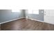 Empty living room showcasing wood floors and natural light from the windows at 1217 S Ewing St, Indianapolis, IN 46203