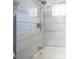 Close up of the bathtub and shower head with modern gray and white striped tiling at 1217 S Ewing St, Indianapolis, IN 46203