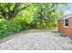 A backyard with green grass and small rocks with many trees at 1231 N Graham Ave, Indianapolis, IN 46219