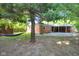 Large backyard has mature trees, shed, brick home, and covered patio at 1231 N Graham Ave, Indianapolis, IN 46219