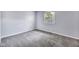Bedroom with light gray walls, gray carpet flooring, and a window with natural light at 1231 N Graham Ave, Indianapolis, IN 46219