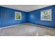 Carpeted bedroom with neutral trim features natural light from two windows at 1231 N Graham Ave, Indianapolis, IN 46219