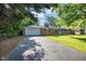 Charming brick home with an attached garage, mature trees, and a large driveway with ample parking at 1231 N Graham Ave, Indianapolis, IN 46219