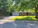 Charming brick home featuring an attached garage, freshly cut lawn, and mature trees providing ample shade at 1231 N Graham Ave, Indianapolis, IN 46219