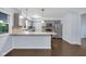 Modern kitchen with stainless steel appliances, stylish cabinets, and a breakfast bar with hardwood floors at 1231 N Graham Ave, Indianapolis, IN 46219