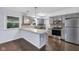Modern kitchen with stainless steel appliances, gray cabinets, and a breakfast bar, perfect for casual dining at 1231 N Graham Ave, Indianapolis, IN 46219