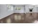 Living room with wood-look flooring, a fireplace, and natural light from multiple windows at 1231 N Graham Ave, Indianapolis, IN 46219