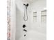 Elegant bathroom featuring a soaking tub with a shower, floral curtain, and white marble tile at 12404 Guy Way, Indianapolis, IN 46236