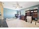 Bright bedroom with a ceiling fan, filled with a desk, bookcases, and ample space for relaxation and productivity at 12404 Guy Way, Indianapolis, IN 46236